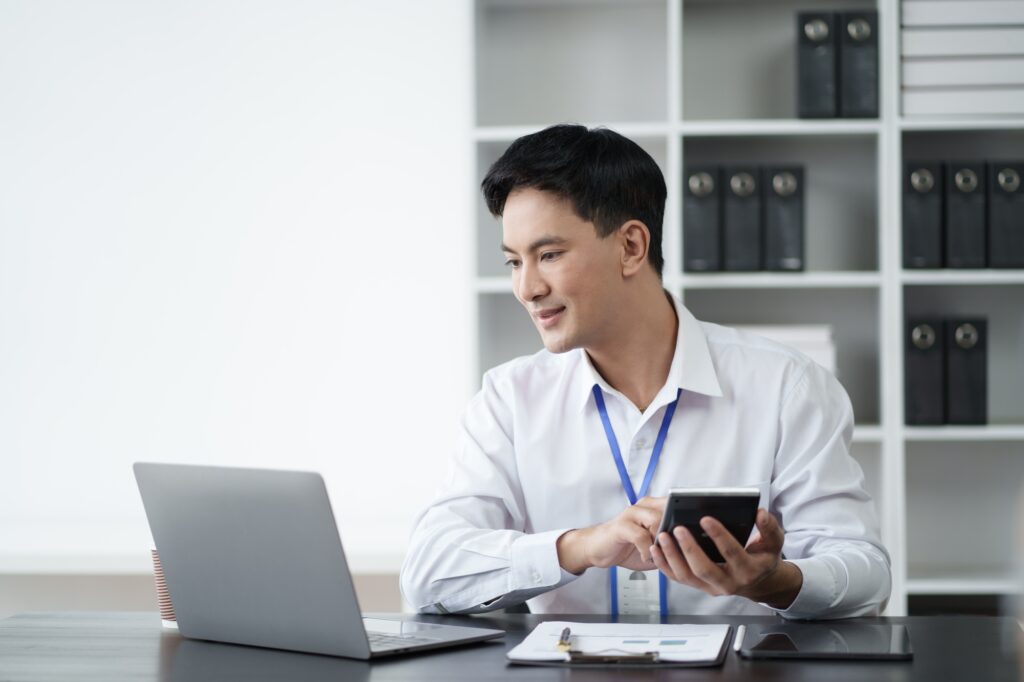 Young Asian businessman use digital calculator for tax, salary and personal expenses.